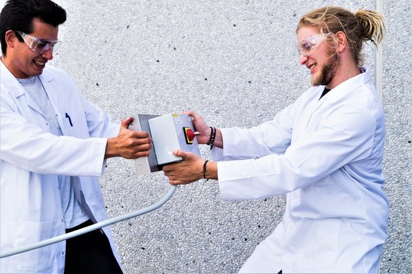 Kemi-ingeniørerne Inuk Kanuthsen og Kasper L. Jørgensen afprøver hæftningen af plastic til metal. Foto: Radisurf