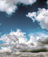 Foto af hvide og grå skyer på en blå himmel.