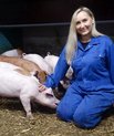 Billede af Elvira der sidder ved siden af grise