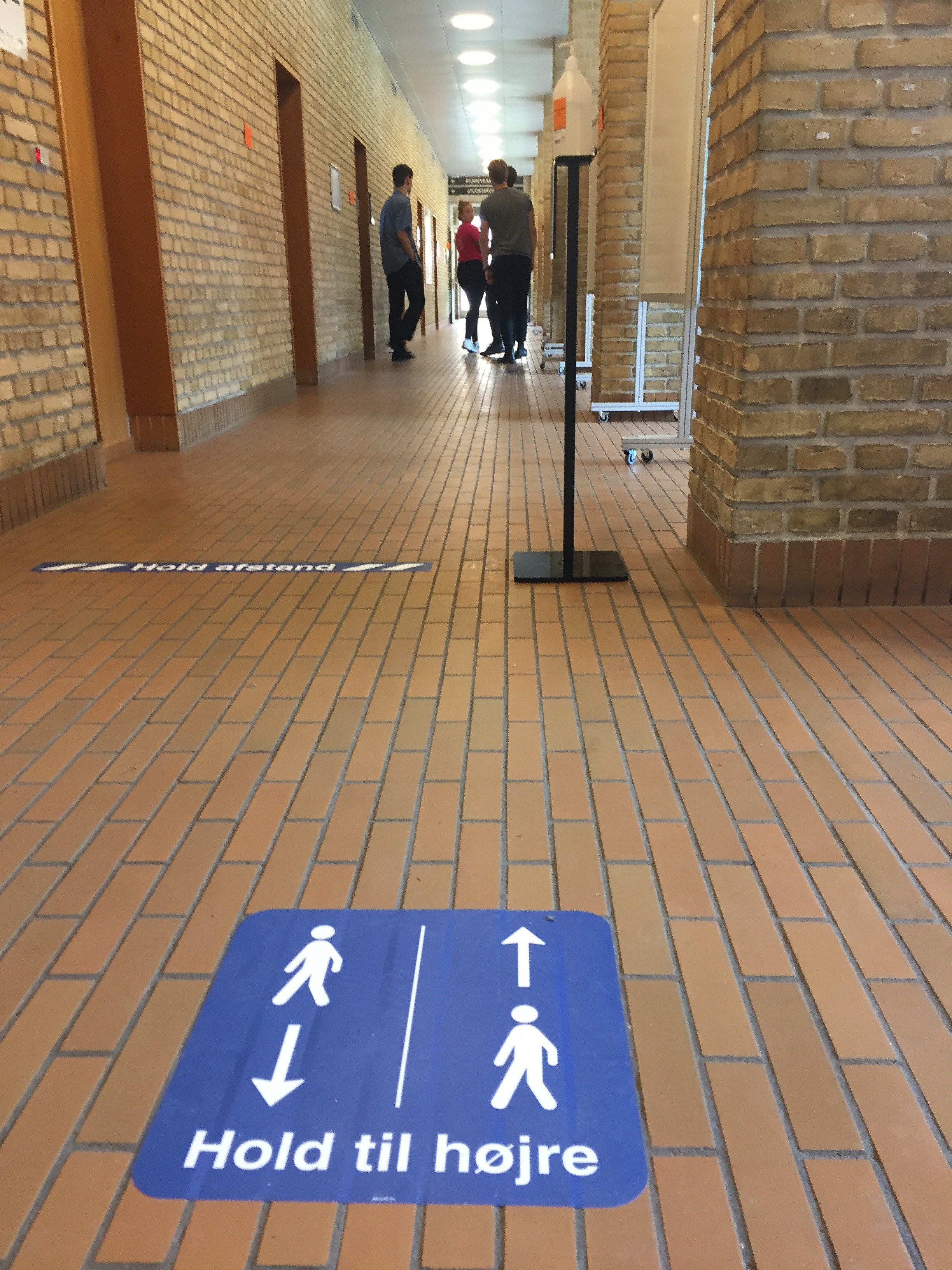 Rundt omkring i bygningerne bliver der på forskellig vis vejledt i at holde afstand, holde til højre og undgå trængsel. Foto: Christina Troelsen